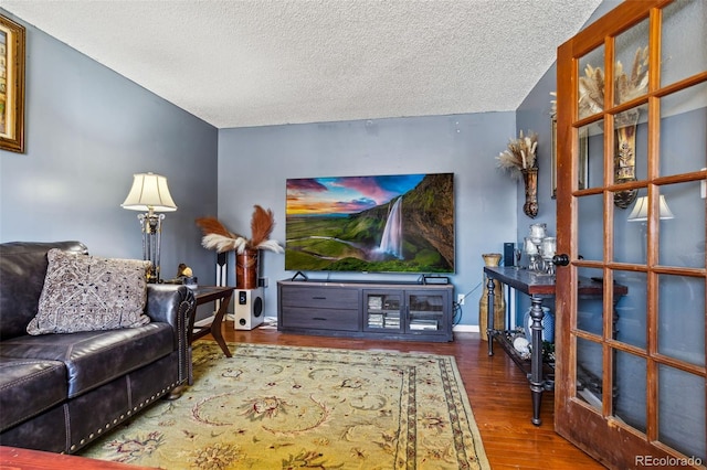 living area with a textured ceiling, wood finished floors, and baseboards