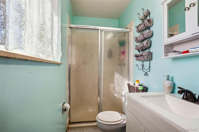 full bath with a stall shower, vanity, and toilet