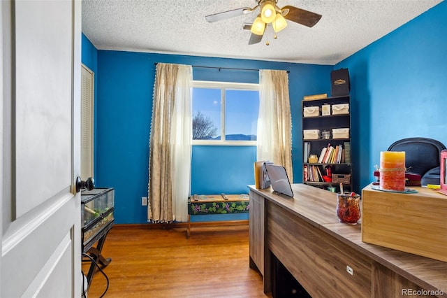 office featuring a textured ceiling, wood finished floors, and a ceiling fan