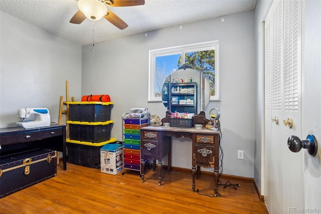 office with ceiling fan, a textured ceiling, baseboards, and wood finished floors