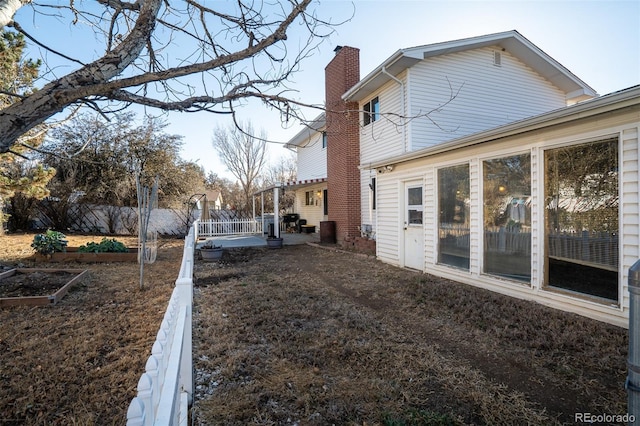 exterior space featuring a patio area, a garden, and fence