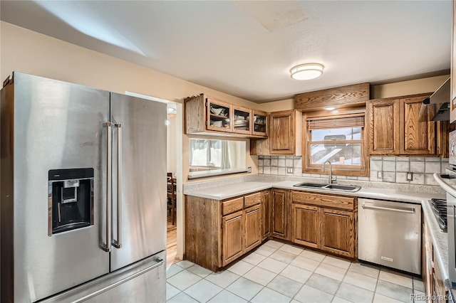 7005 S Ash Cir, Centennial, CO 80122 - kitchen featuring a sink, brown cabinetry, backsplash, light countertops, and appliances with stainless steel finishes