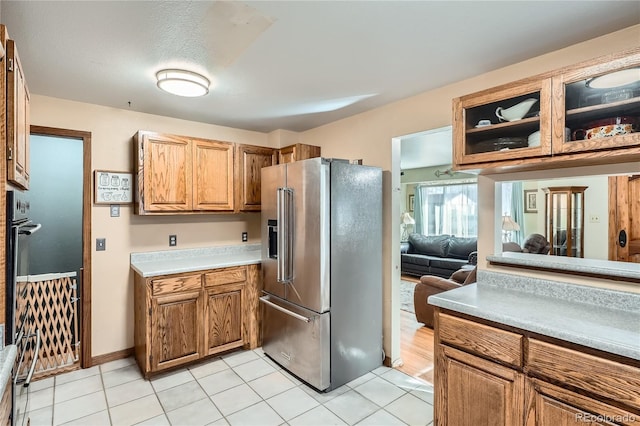 7005 S Ash Cir, Centennial, CO 80122 - kitchen with light countertops, high end fridge, brown cabinets, and light tile patterned flooring