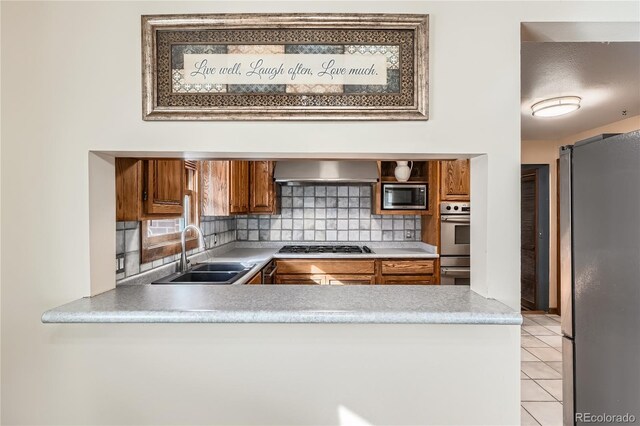 7005 S Ash Cir, Centennial, CO 80122 - kitchen with a sink, brown cabinetry, stainless steel appliances, tasteful backsplash, and wall chimney exhaust hood