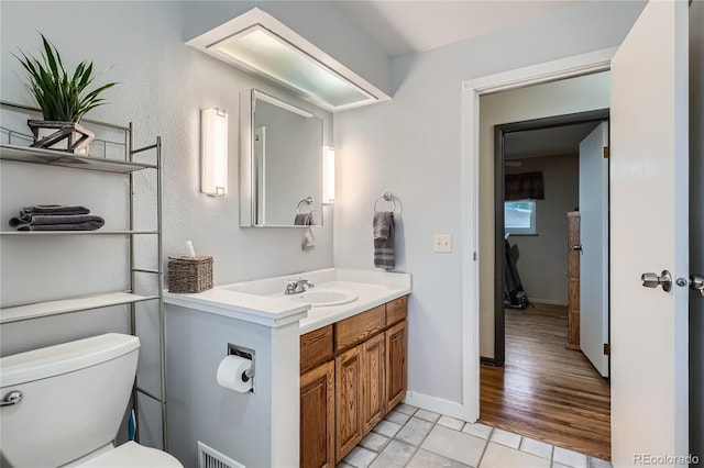 7005 S Ash Cir, Centennial, CO 80122 - half bath with toilet, baseboards, visible vents, tile patterned flooring, and vanity
