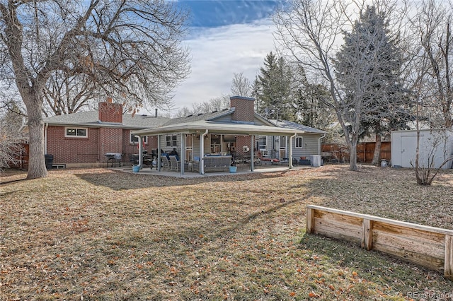 7005 S Ash Cir, Centennial, CO 80122 - back of property featuring a chimney, brick siding, fence, a patio area, and a storage unit