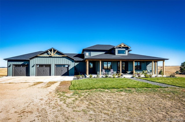 view of front of property with a porch, a garage, and a front lawn