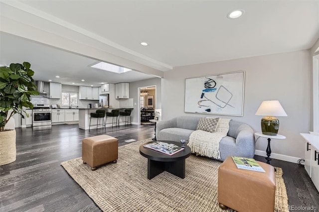 living room featuring baseboards, dark wood finished floors, and recessed lighting