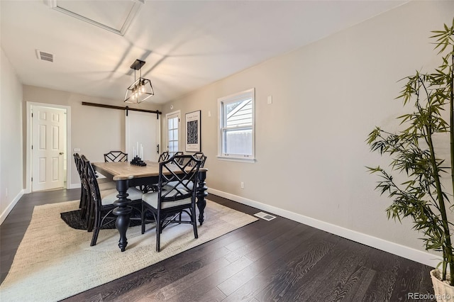 dining area with dark wood finished floors, visible vents, and baseboards