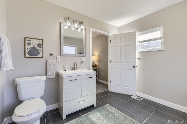 bathroom with baseboards, vanity, and toilet