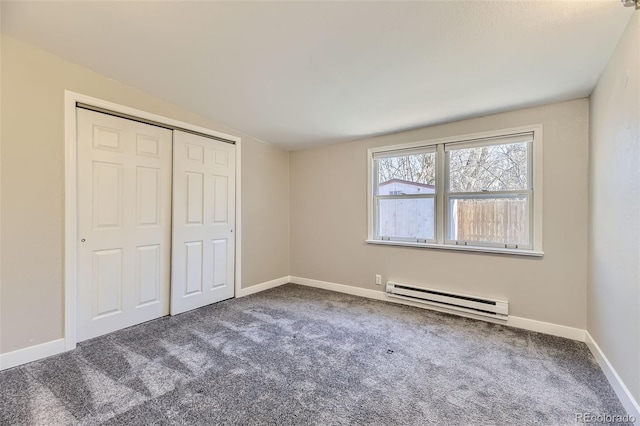 unfurnished bedroom featuring a baseboard heating unit, a closet, carpet floors, and baseboards