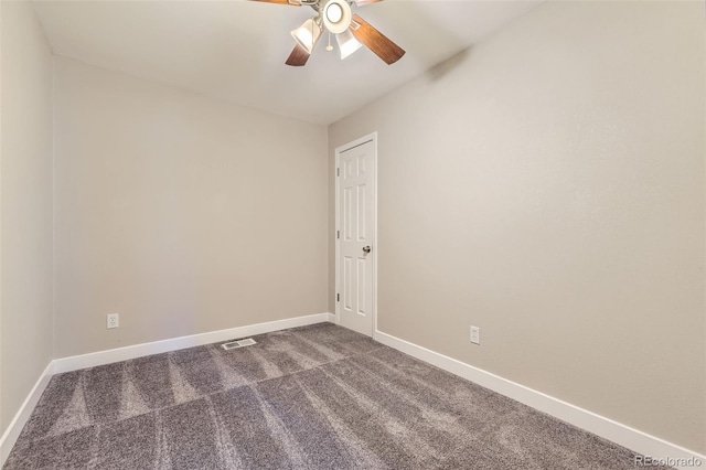 spare room featuring visible vents, baseboards, dark colored carpet, and a ceiling fan