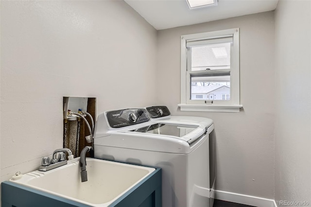 laundry room with laundry area, baseboards, a sink, and independent washer and dryer