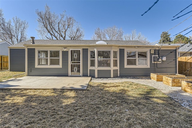 rear view of house featuring a yard, a patio area, fence, and a vegetable garden