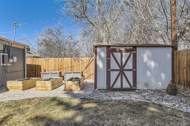 view of shed with a fenced backyard and a vegetable garden