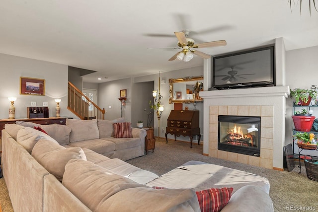 living room featuring carpet, ceiling fan, and a tiled fireplace