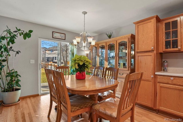 dining space featuring light hardwood / wood-style floors and a notable chandelier