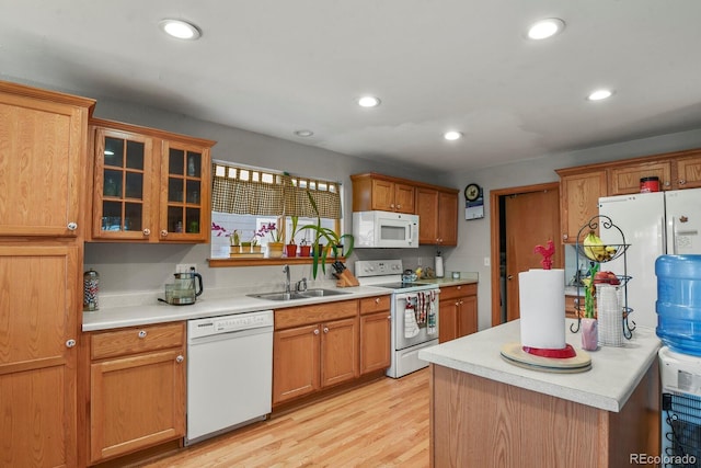 kitchen with sink, light hardwood / wood-style floors, and white appliances