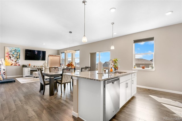 kitchen with an island with sink, stainless steel dishwasher, sink, and a wealth of natural light