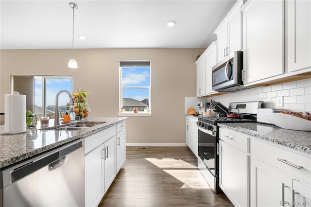 kitchen featuring appliances with stainless steel finishes, white cabinetry, sink, and a wealth of natural light