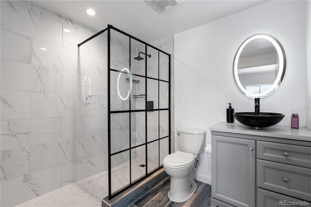 bathroom featuring toilet, an enclosed shower, hardwood / wood-style flooring, and vanity