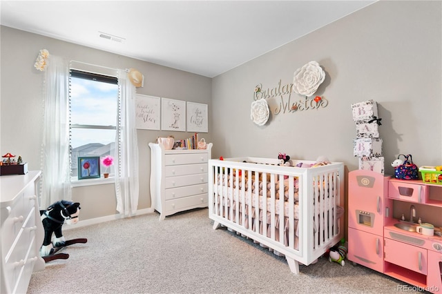 carpeted bedroom with a nursery area