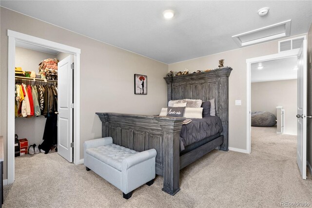 carpeted bedroom featuring a spacious closet and a closet