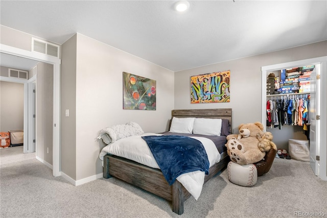 bedroom featuring a closet, a spacious closet, and light colored carpet