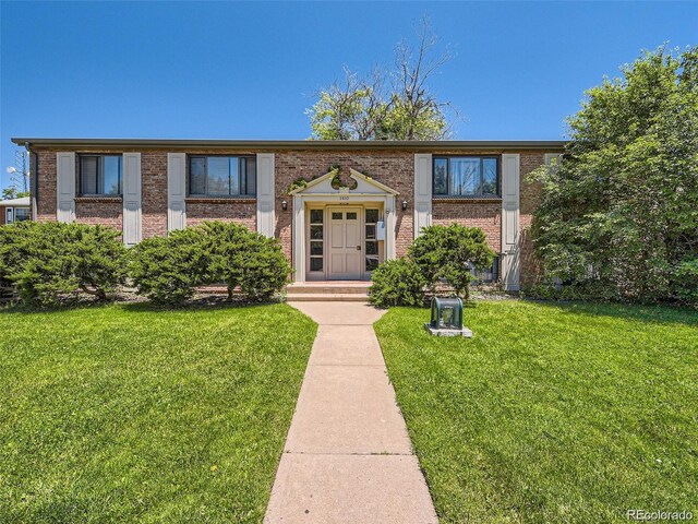1410 S Ash St, Denver, CO 80222 - view of front of house featuring brick siding and a front lawn