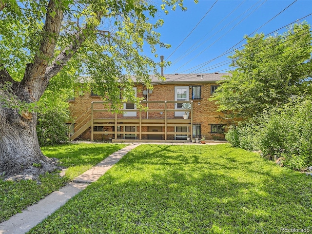 1410 S Ash St, Denver, CO 80222 - rear view of property featuring a wooden deck, a yard, and brick siding