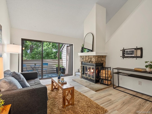 7379 S Gore Range Rd Unit 304, Littleton, CO 80127 - living room featuring wood finished floors, a stone fireplace, and high vaulted ceiling