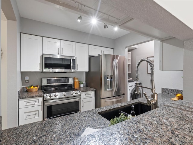 7379 S Gore Range Rd Unit 304, Littleton, CO 80127 - kitchen with appliances with stainless steel finishes, dark stone counters, white cabinetry, and rail lighting