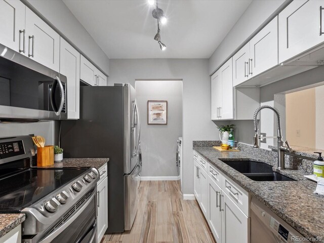 7379 S Gore Range Rd Unit 304, Littleton, CO 80127 - kitchen with stainless steel appliances, light wood-style floors, white cabinetry, stone counters, and track lighting