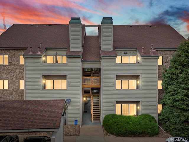 7379 S Gore Range Rd Unit 304, Littleton, CO 80127 - view of front of home with a chimney, a shingled roof, and stairway