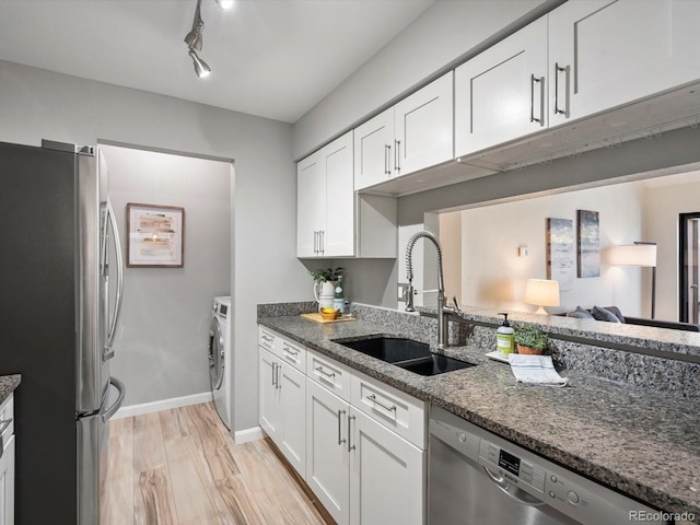 7379 S Gore Range Rd Unit 304, Littleton, CO 80127 - kitchen with appliances with stainless steel finishes, dark stone countertops, white cabinetry, and light wood-type flooring