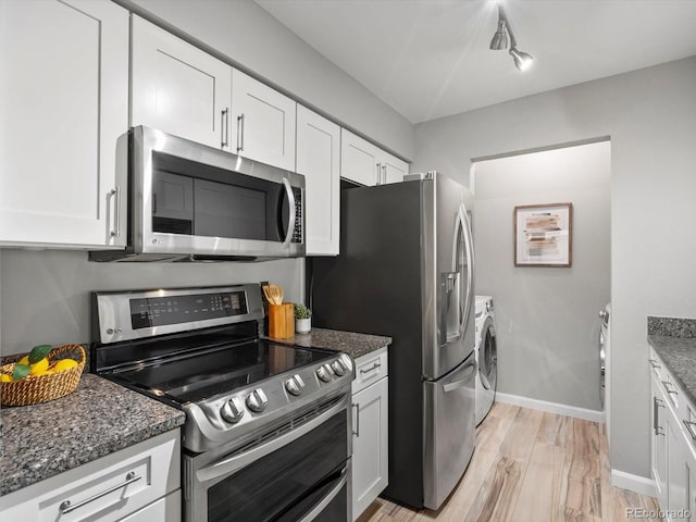 7379 S Gore Range Rd Unit 304, Littleton, CO 80127 - kitchen with stainless steel appliances, separate washer and dryer, white cabinets, and dark stone countertops