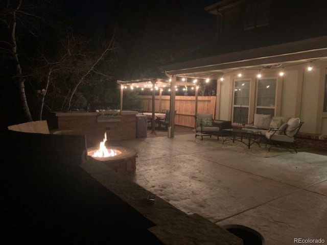 patio at twilight featuring an outdoor living space with a fire pit