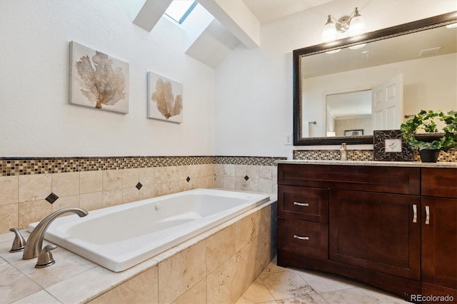 bathroom featuring vanity, tile patterned flooring, a skylight, and tiled bath