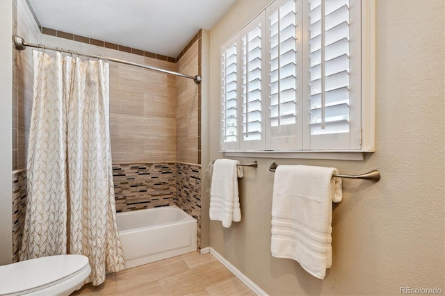 bathroom with shower / bath combination with curtain and toilet