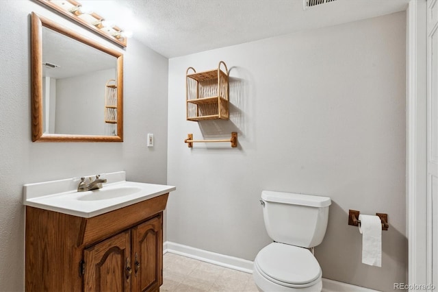 bathroom featuring toilet, a textured ceiling, and vanity