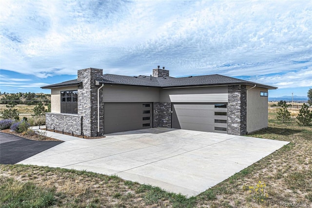 view of front of home with a chimney, an attached garage, and concrete driveway