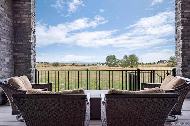 deck with an outdoor hangout area and a rural view