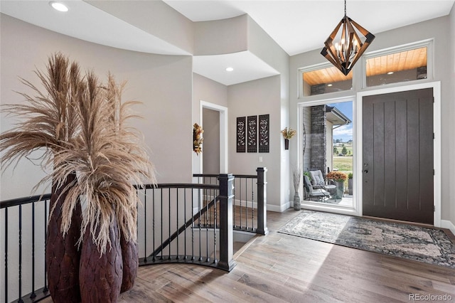 entrance foyer with recessed lighting, baseboards, a notable chandelier, and wood finished floors