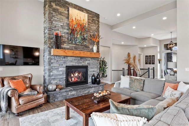 living area featuring a fireplace, recessed lighting, wood finished floors, and baseboards