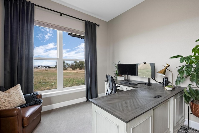 office with baseboards, light carpet, and a healthy amount of sunlight