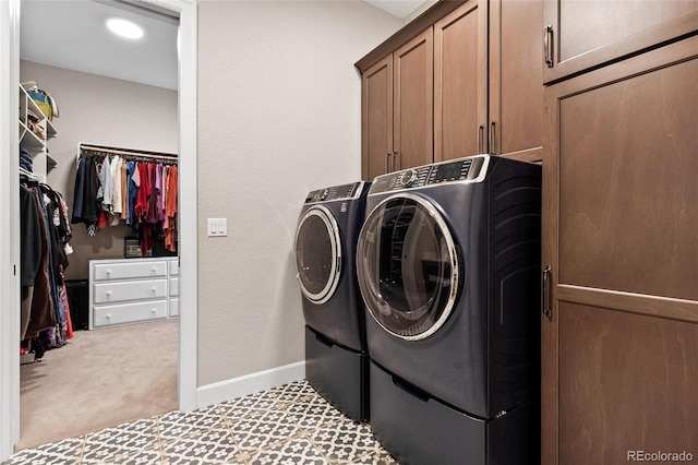 clothes washing area with cabinet space, carpet flooring, washer and dryer, and baseboards