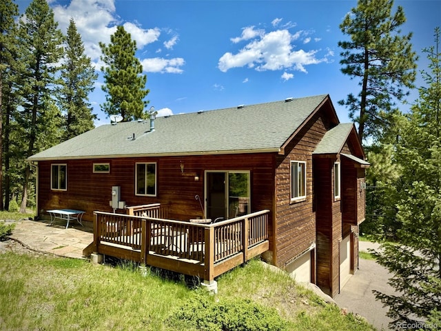6752 S Columbine Rd, Evergreen, CO 80439 - rear view of house with roof with shingles, a deck, a patio area, driveway, and an attached garage