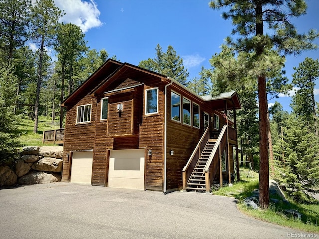 6752 S Columbine Rd, Evergreen, CO 80439 - view of front of home featuring asphalt driveway, a garage, and stairway