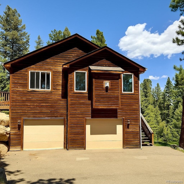 6752 S Columbine Rd, Evergreen, CO 80439 - chalet / cabin featuring a garage, stairs, and driveway
