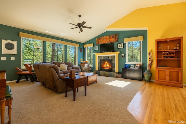 6752 S Columbine Rd, Evergreen, CO 80439 - carpeted living room featuring a tiled fireplace, ceiling fan, lofted ceiling, and wood finished floors
